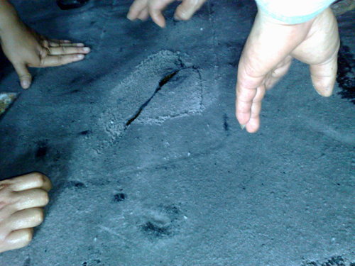 Hands pointing to damaged areas on a tank lining surface